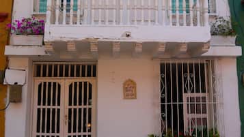Un immeuble à la façade blanche, doté d’un balcon avec des balustrades blanches, et d’une enseigne indiquant « Casa Mary 29-89 ».