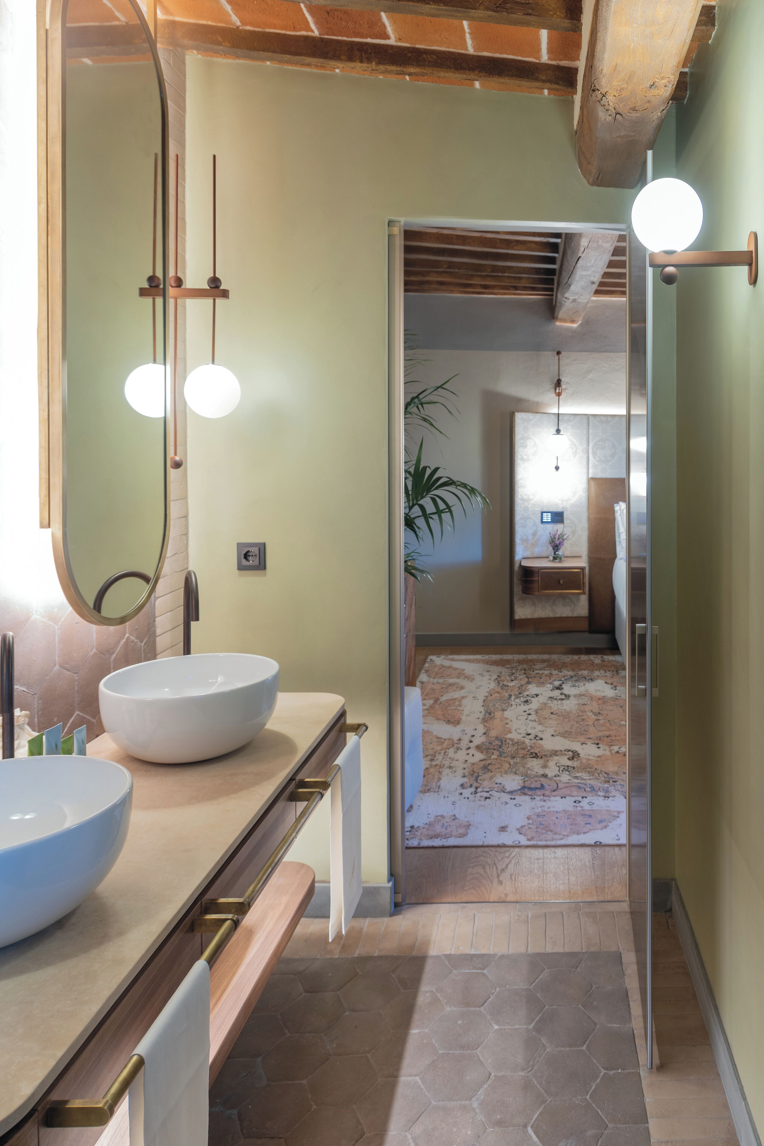 Un bagno moderno con un lavandino bianco grande, uno specchio e un corpo illuminante sopra lo specchio.