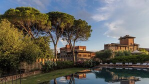 A large, historic building with a swimming pool and lounge chairs. - Borgo Dei Conti Resort Relais & Chateaux (Perugia)