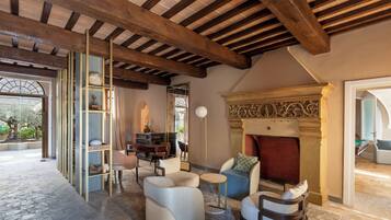 Un salón acogedor con chimenea, asientos cómodos y vistas al exterior.