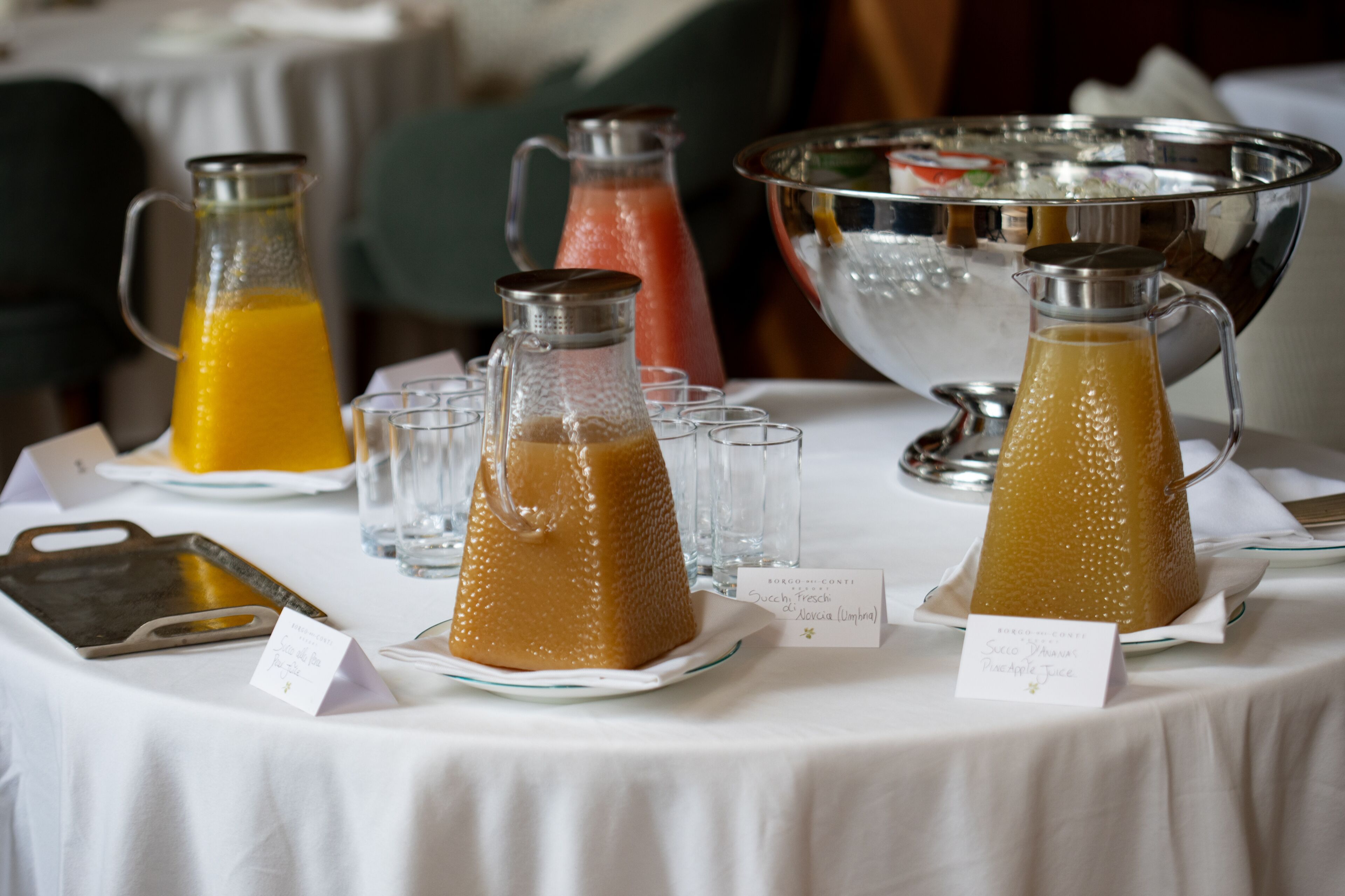 Una mesa con diversas bebidas y una fuente de plata.