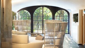 A modern lounge area with wicker furniture, a sofa, and a coffee table. - Borgo Dei Conti Resort Relais & Chateaux (Perugia)