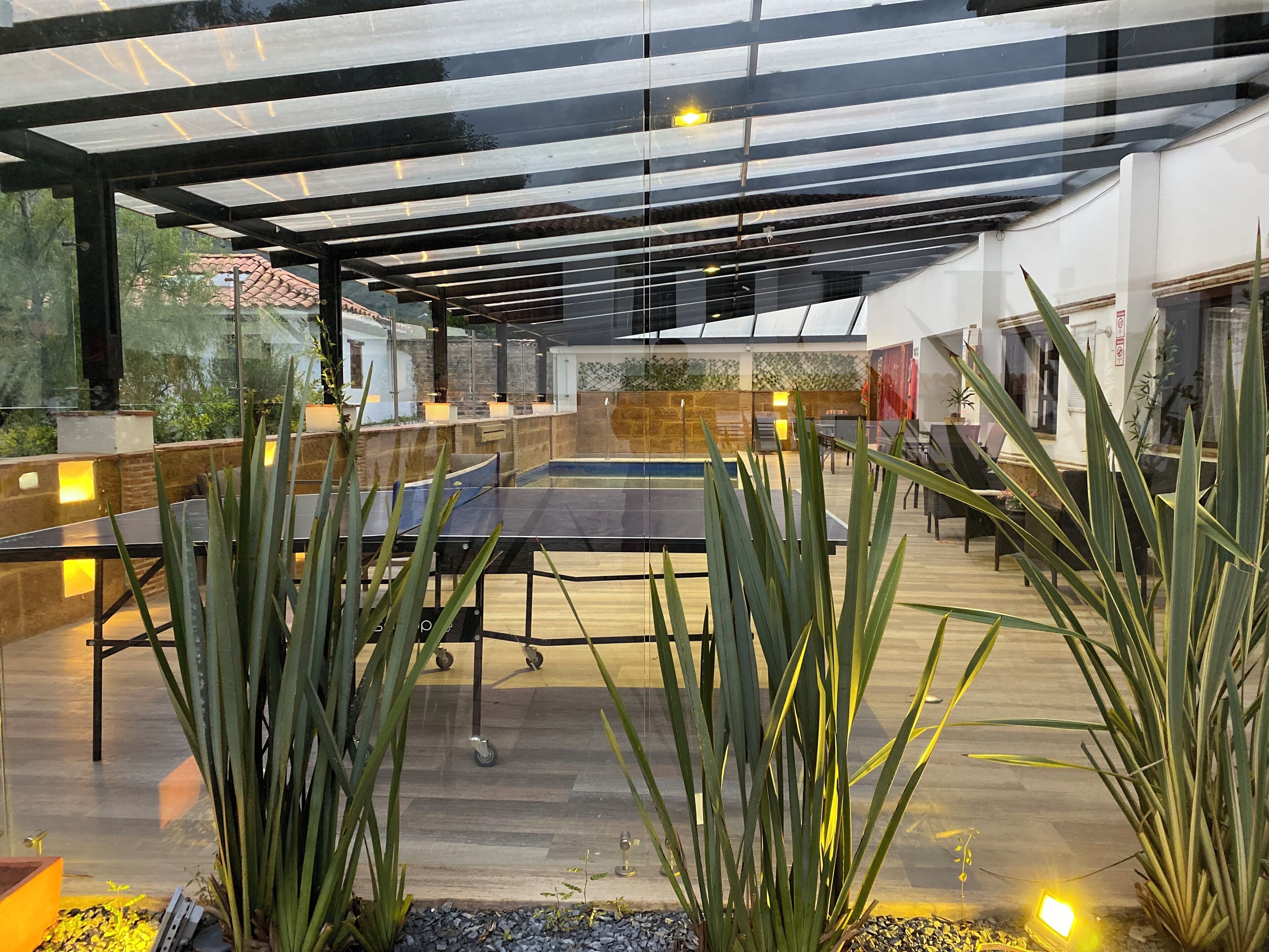 Een binnenzwembad, parasols bij het zwembad en ligstoelen