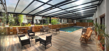 Una piscina techada, abierta desde las 10:00 hasta las 20:00, sombrillas