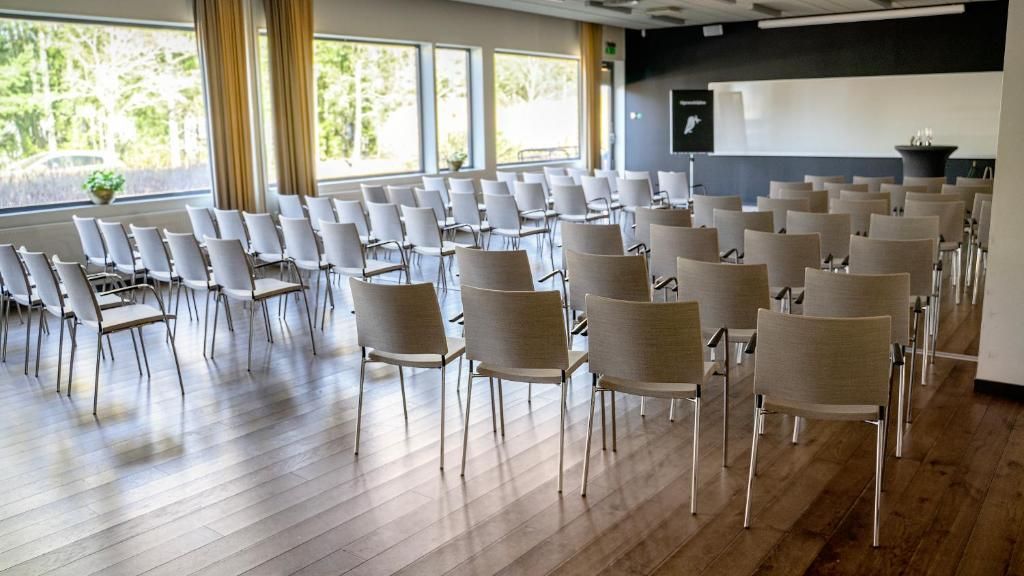 A conference room with rows of chairs arranged for a meeting.