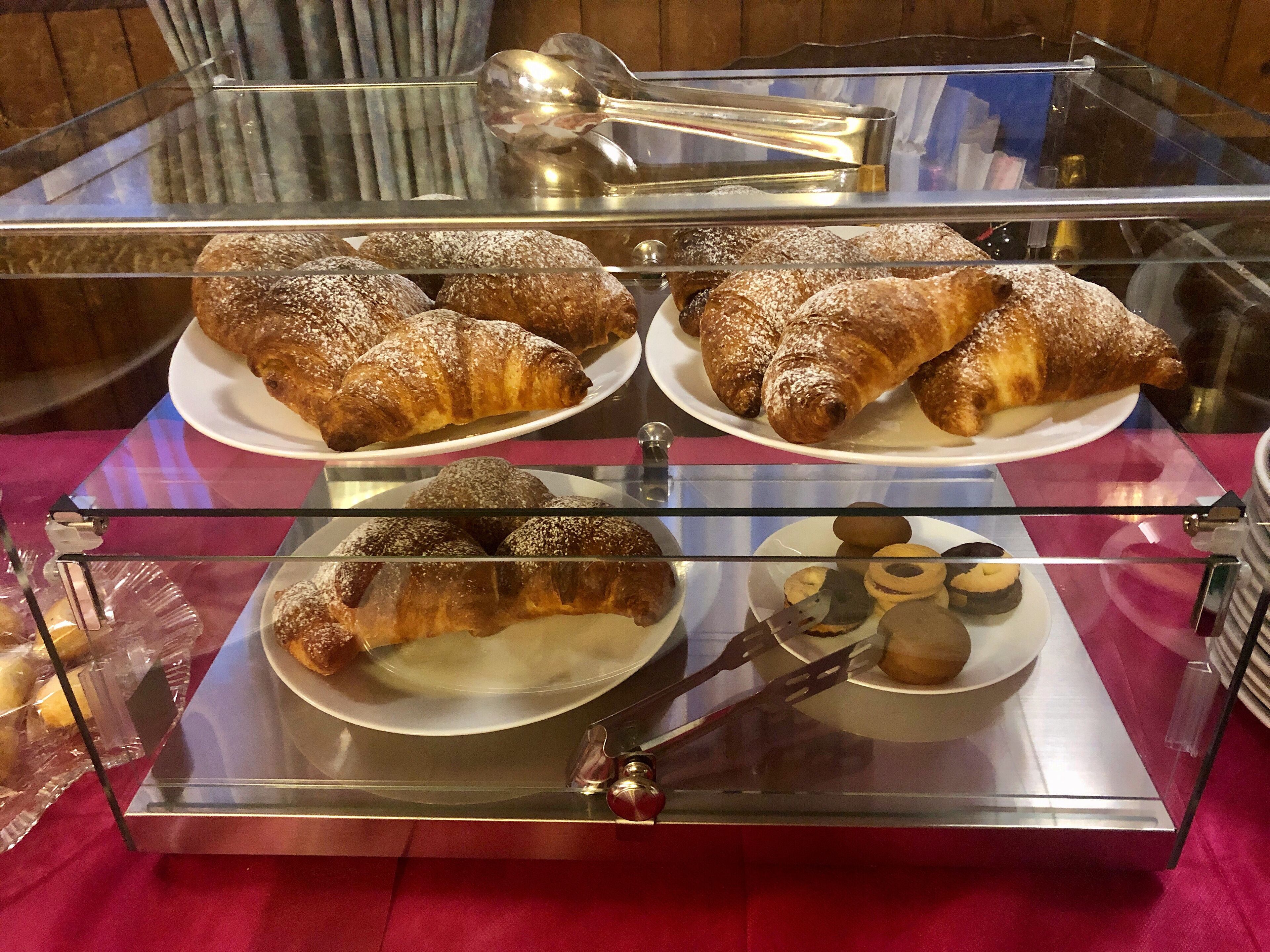 Ett skyltfönster från ett bageri med bakverk och en sked.