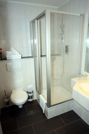 Twin kamer | Badkamer | Een douche, een haardroger, handdoeken