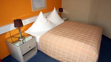 Ein Hotelzimmer mit einem Bett, zwei Nachttischen und zwei Lampen.