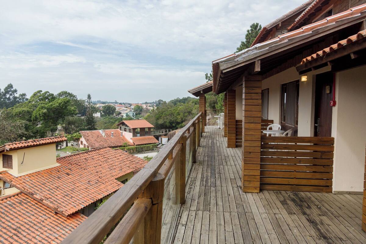 A wooden balcony with a view of a town.
