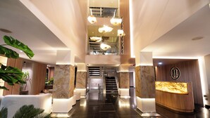 A modern lobby with a reception desk, a staircase, and a large plant. - ZiOne Luxury Hotel Pereira (Pereira)