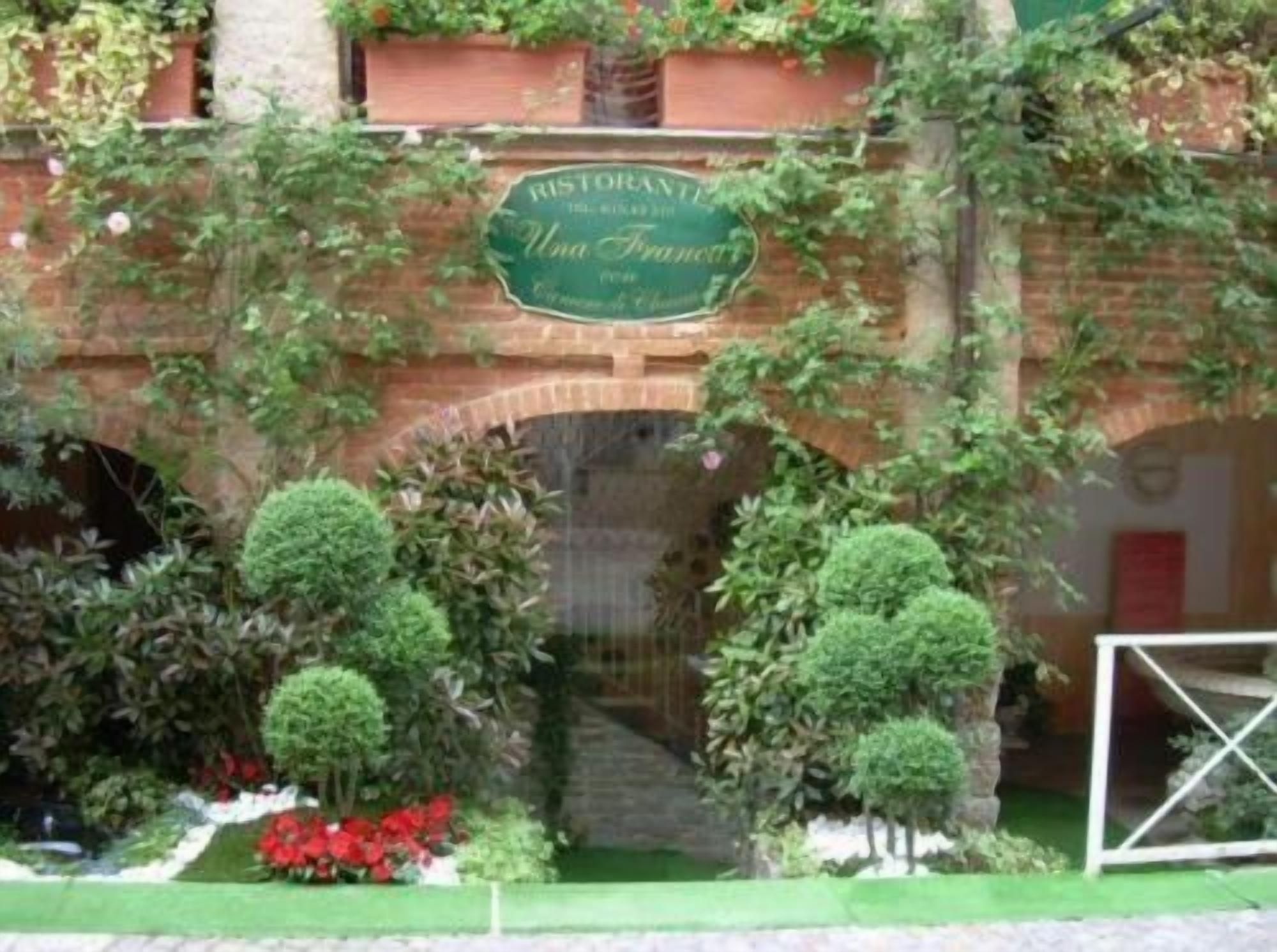 A brick archway with a sign for 'Restaurant Uma Francesca' above it.
