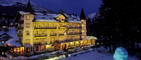 A large, multi-story hotel with snow-covered roofs and a prominent tower.