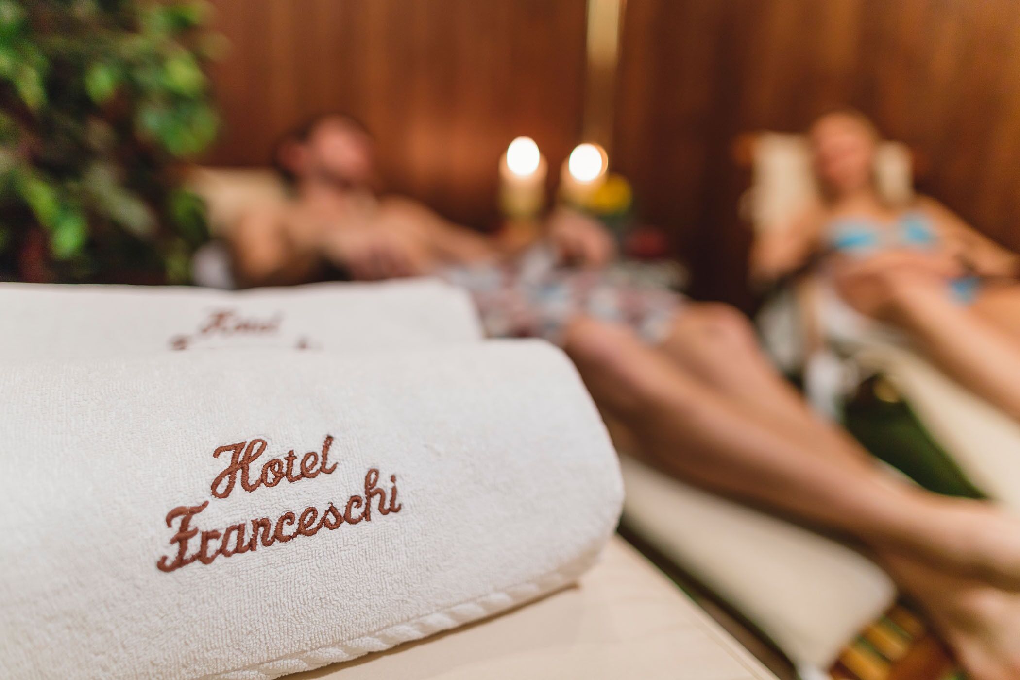 Et hotelværelse med et håndklæde mærket "Hotel Franceschi" og en seng, hvor en person ligger.