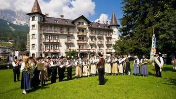 Un hotel con numerosi balconi, in stile architettonico europeo tradizionale, con montagne sullo sfondo.