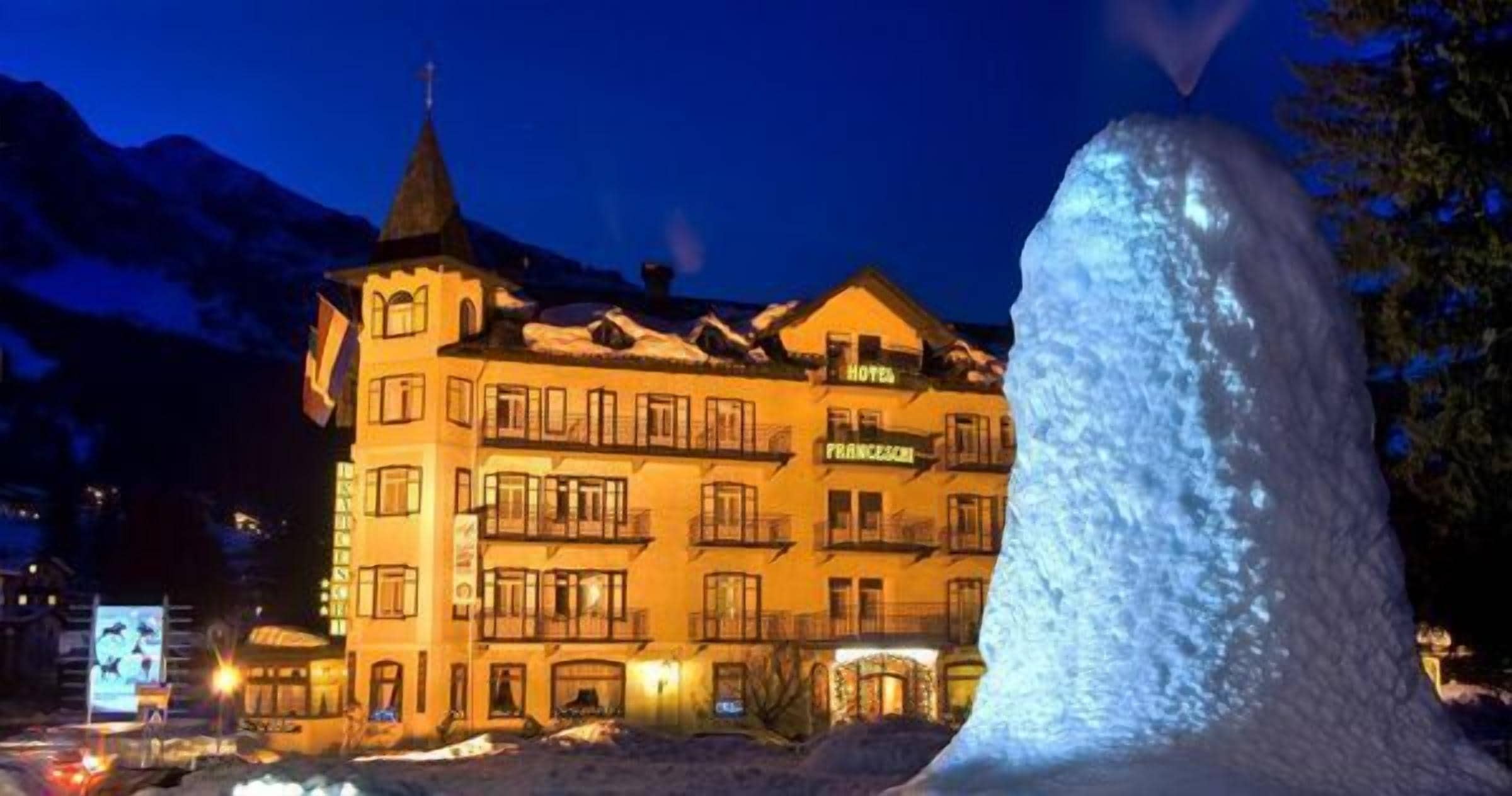 Ein Hotel mit mehreren Balkonen, einem markanten Turm und einem Schild mit der Aufschrift 'HOTEL FRANZESCI'.