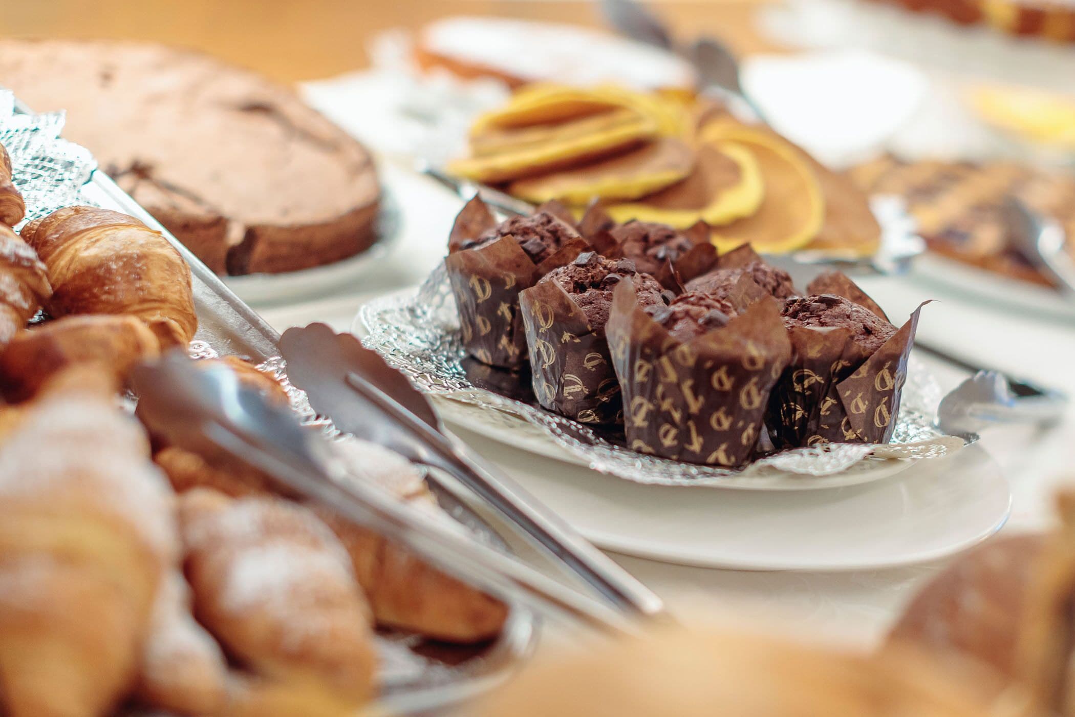 A variety of pastries and desserts on a buffet table.