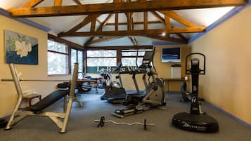 Una palestra con diverse attrezzature per l'allenamento, tra cui tapis roulant, una cyclette e macchinari per pesi.