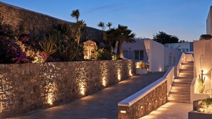 Un sendero de piedra que lleva a una escalera con un edificio blanco al fondo.