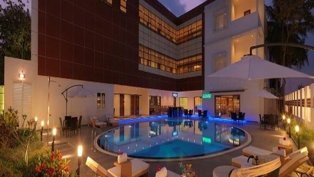 Un hotel moderno con piscina, zona de estar al aire libre y un patio bien iluminado.