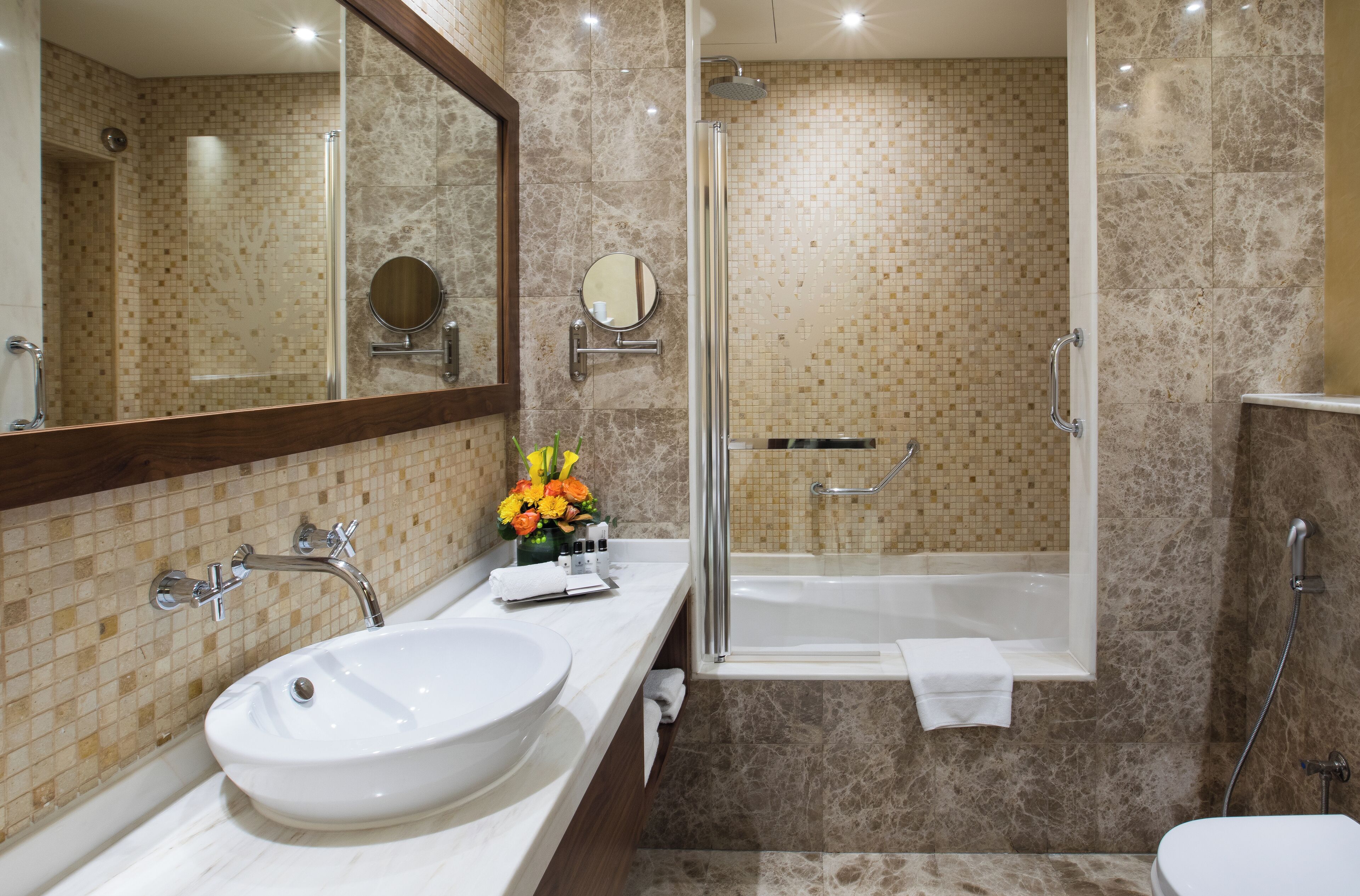 Un bagno con un lavandino bianco ampio, uno specchio, una doccia e una vasca da bagno.