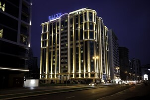 A multi-story hotel with illuminated signage, a prominent entrance, and a well-lit facade.