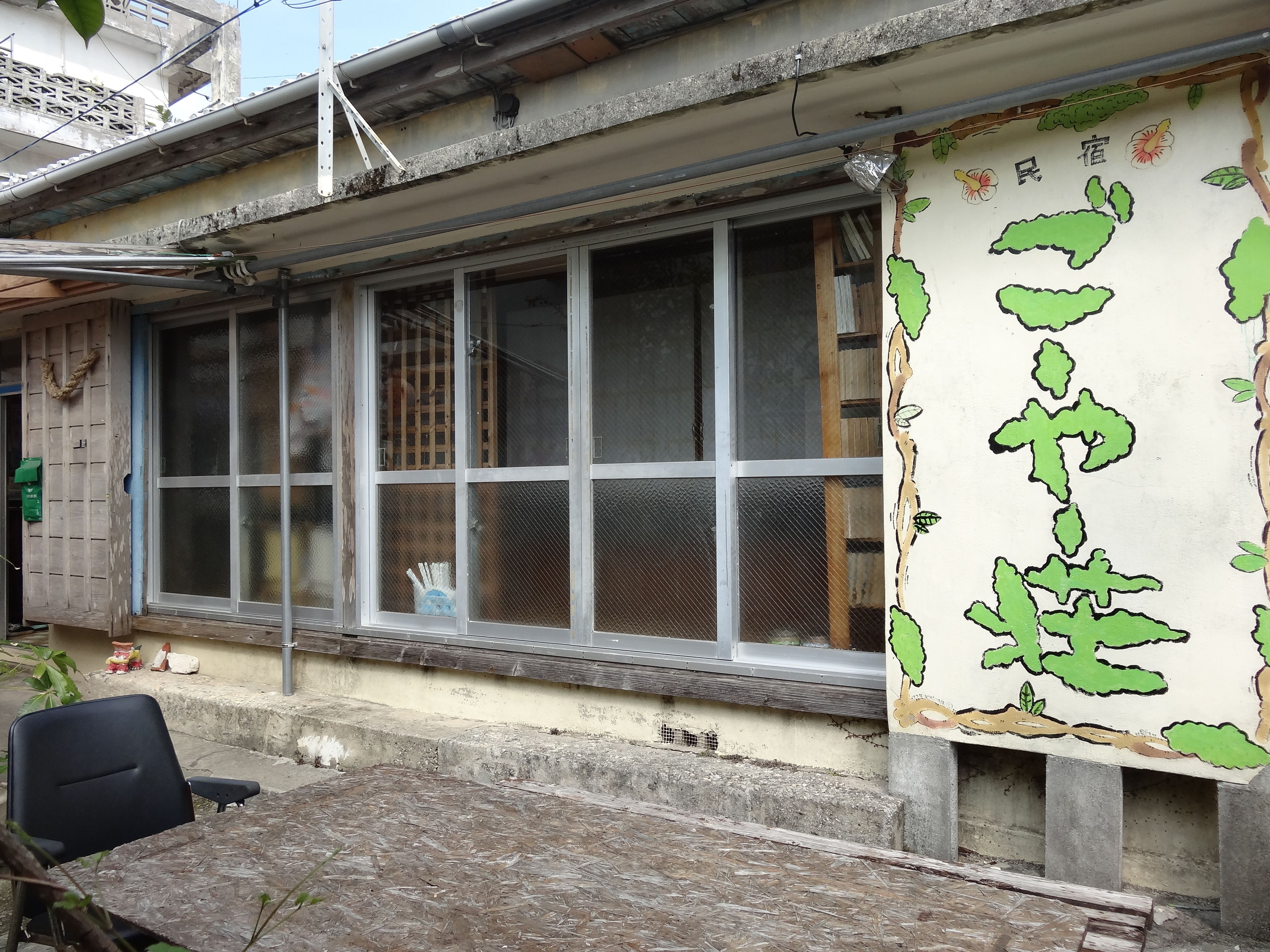 A building with large windows, a concrete exterior, and a green banner with Chinese characters.