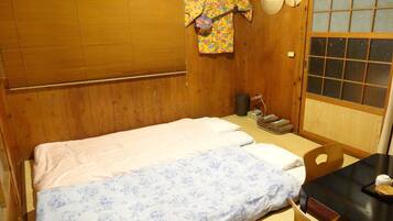 Um quarto japonês tradicional com cama, paredes de madeira, esteira de tatame e um painel shoji.