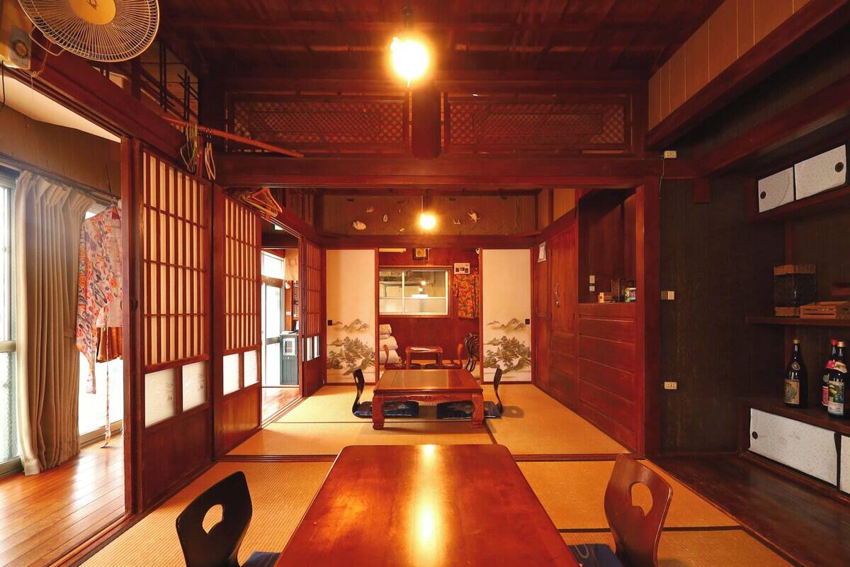 A traditional Japanese room with tatami flooring, a low wooden table, and sliding doors.