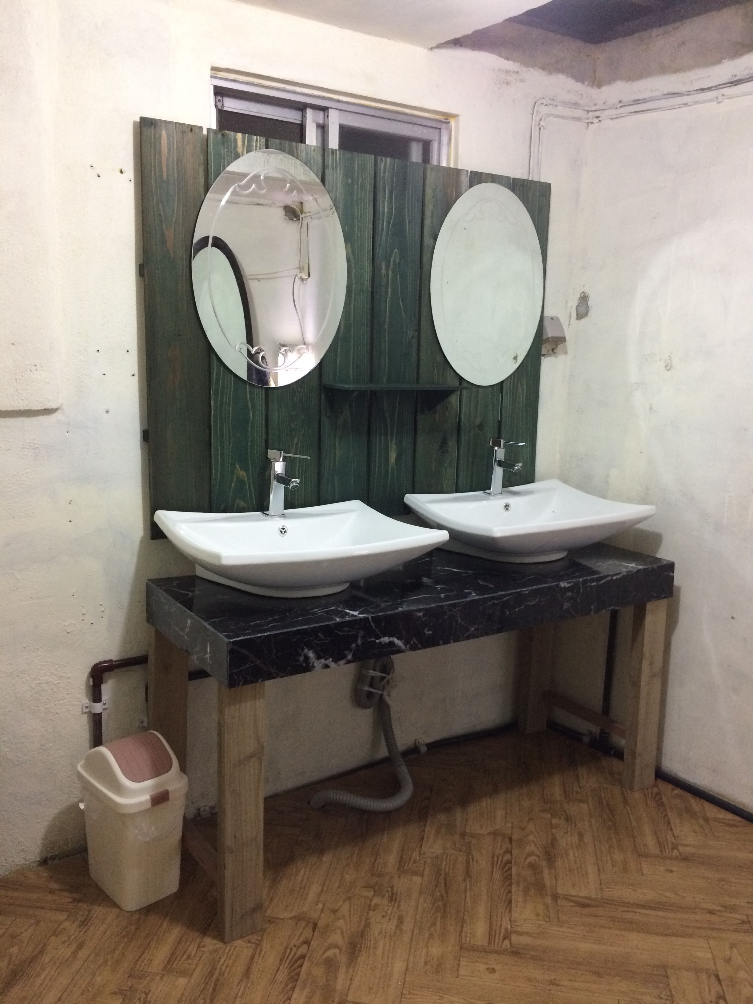 A bathroom with two sinks, wooden vanity, and a mirror.