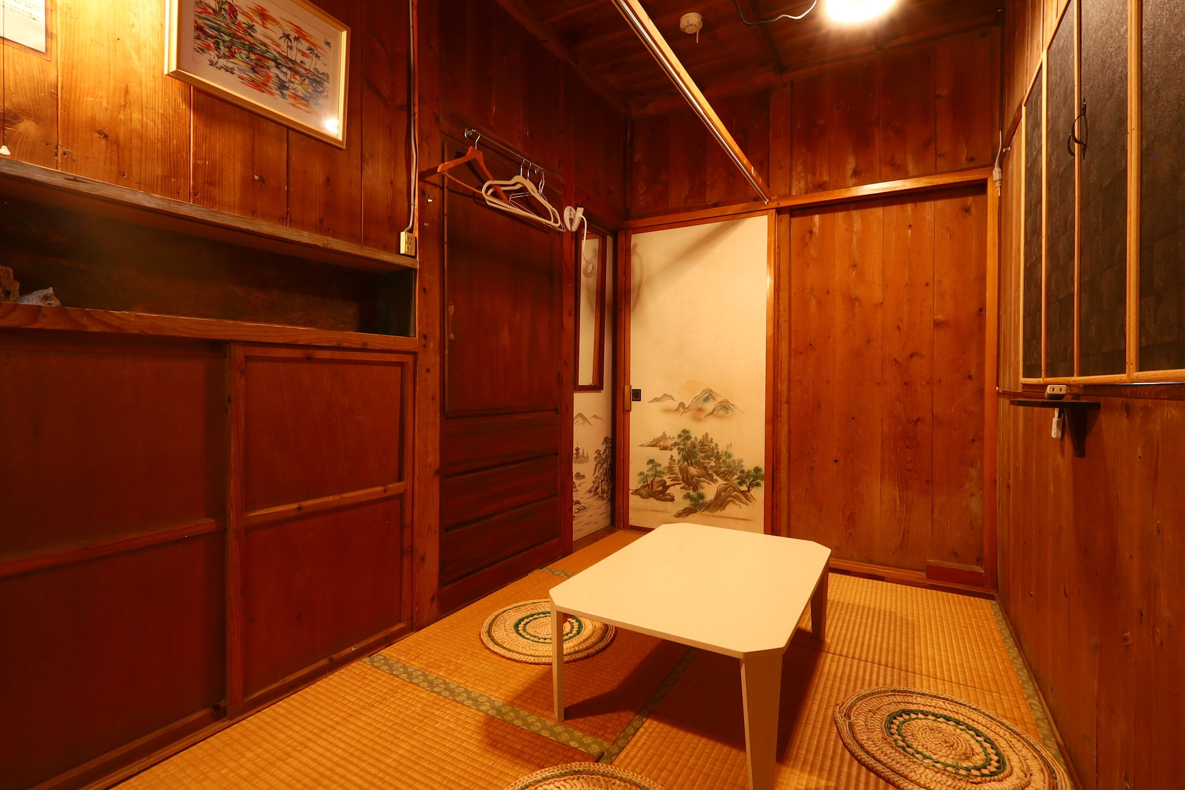 A traditional Japanese room with tatami flooring, a low table, and sliding doors.