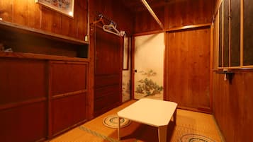 A traditional Japanese room with tatami flooring, a low table, and sliding doors.