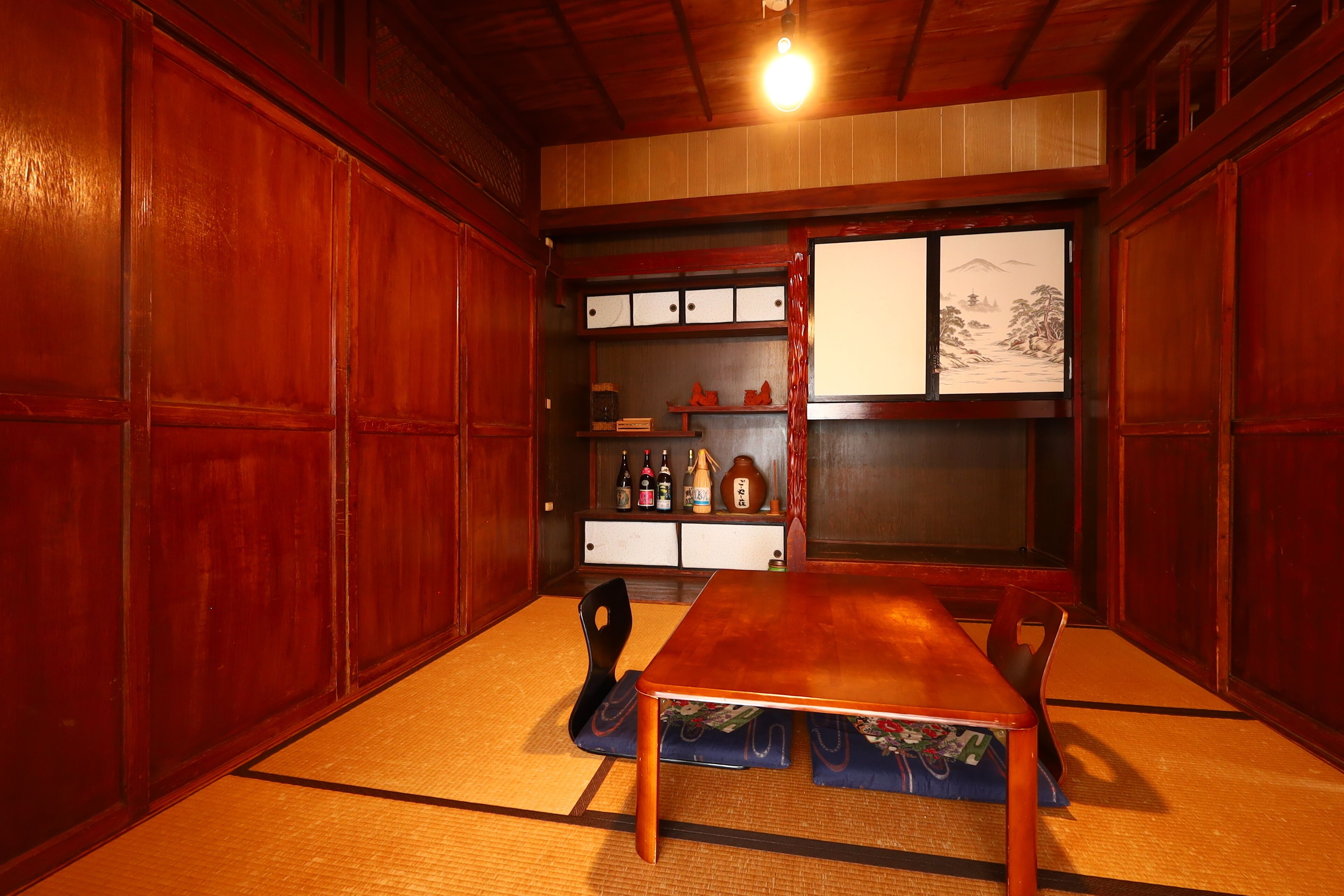 A traditional Japanese room with tatami flooring, a low wooden table, and sliding doors.