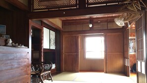 Una habitación japonesa tradicional con suelo de tatami, puertas correderas y decoración de madera.