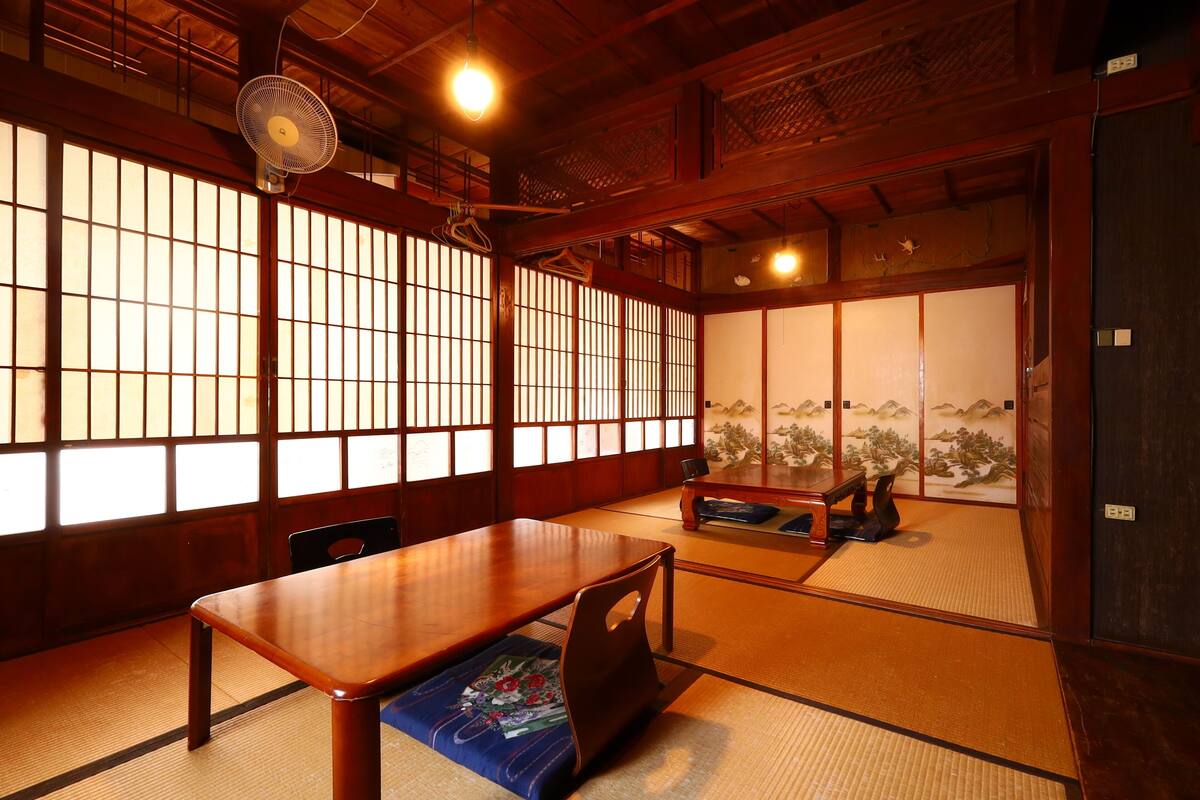 A traditional Japanese room with tatami flooring, a low wooden table, and sliding doors.