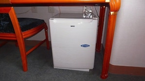 A compact white refrigerator under a wooden table with a chair. - Hotel Kizankan (Tokyo)