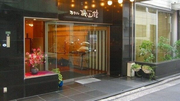 A modern building with a glass entrance and a sign above it. - Hotel Kizankan (Tokyo)
