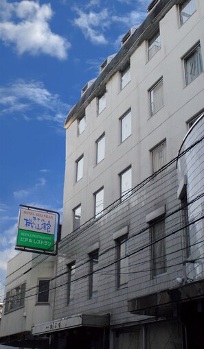 Un immeuble à plusieurs étages, sur lequel on peut lire une enseigne indiquant « Hôtel Kizankan », ce qui signifie qu’il propose de la bière et un restaurant.