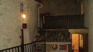 A rustic interior with a staircase leading to a wooden loft.