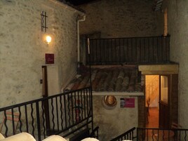 Un interior rústico con una escalera que lleva a un altillo de madera.
