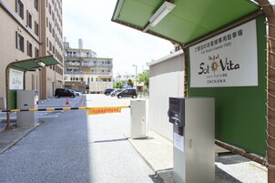 Entrada de un hotel con un letrero que indica Hotel Sol-Vita en Okinawa.