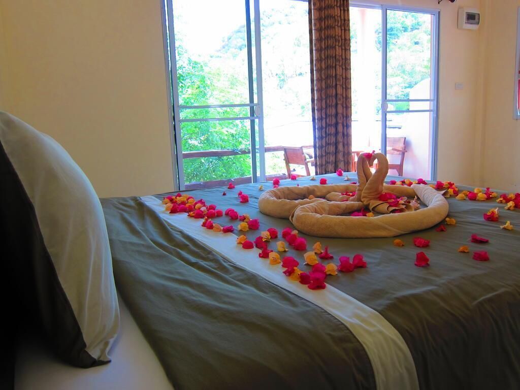 A bed with a heart-shaped arrangement of flowers and a decorative pillow.