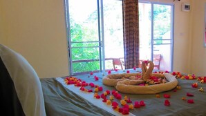 A bed with a heart-shaped arrangement of flowers and a decorative pillow. - Koh Tao Toscana (Koh Tao)