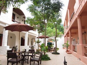 A courtyard with outdoor seating, umbrellas, and potted plants.