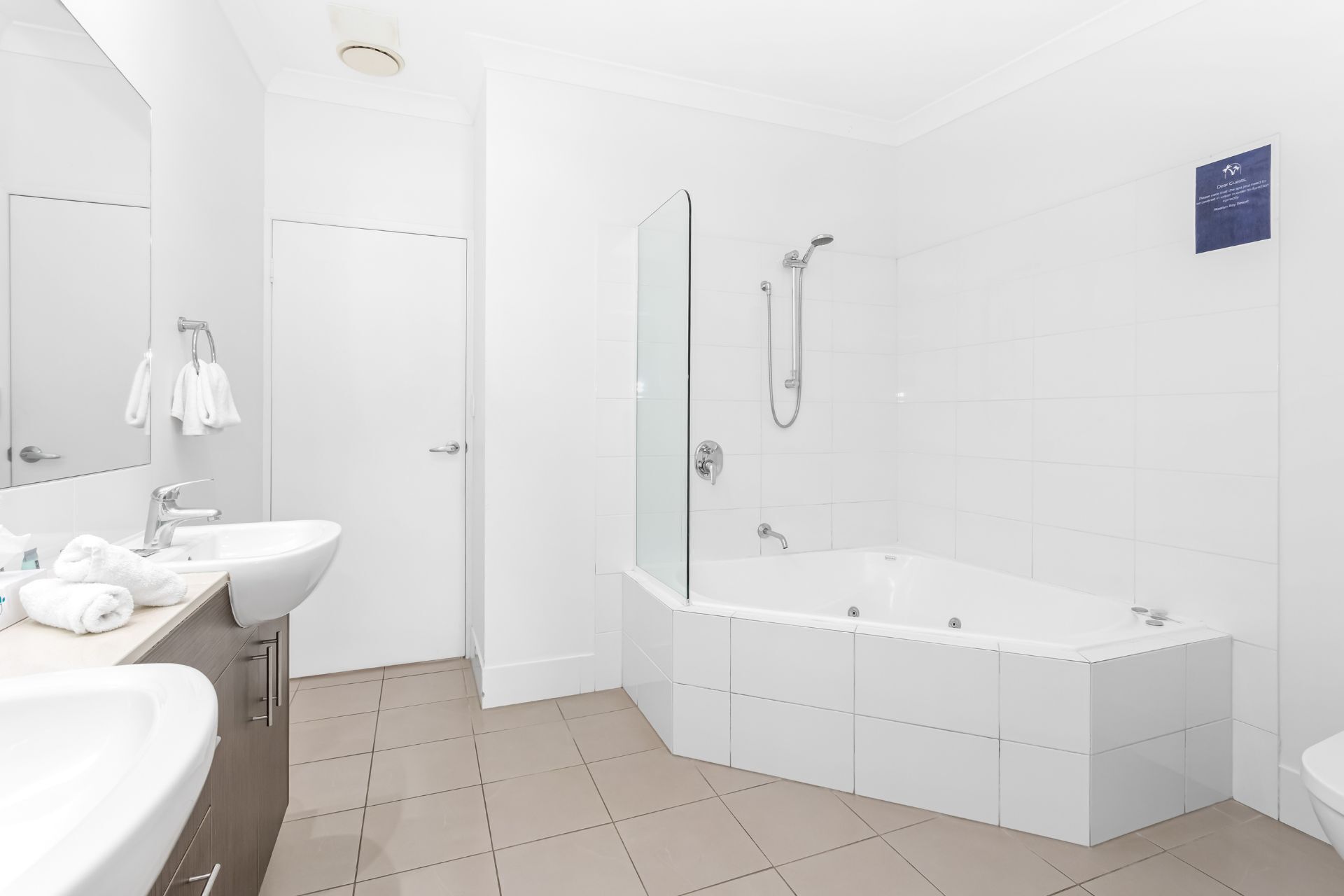 Een moderne badkamer met een ruime badkuip, een aparte douche en een wastafel met spiegel.