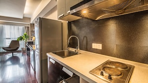 A modern kitchen with stainless steel appliances, a granite countertop, and a built-in stove.