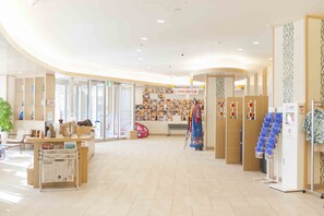 Ein geräumiger, gut beleuchteter Innenraum mit einer Rezeption, einer Sitzecke und einer Wand mit Kinderfotos.