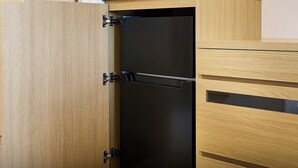 A wooden cabinet with a black appliance, possibly a refrigerator, in a kitchen setting. - Daiwa Roynet Hotel Naha - Kokusaidori (Naha)