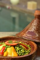 A tagine with vegetables and a lid.