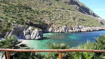 A coastal landscape with rocky cliffs and clear blue waters.
