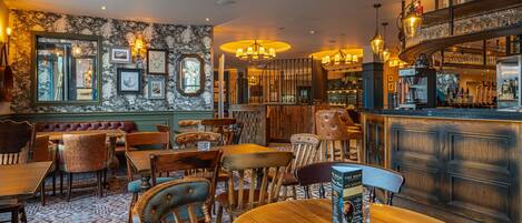 A restaurant with wooden furniture, a bar area, and a patterned carpet.